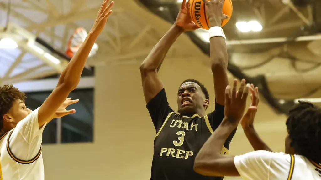 A.J. Dybantsa, wearing a Utah Prep jersey with the number 3, leaps to shoot a basketball as three defenders attempt to block him during a high school game.