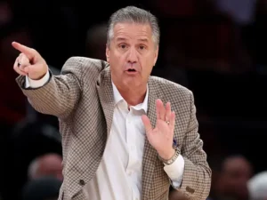 John Calipari pointing and gesturing on the sidelines during a basketball game.